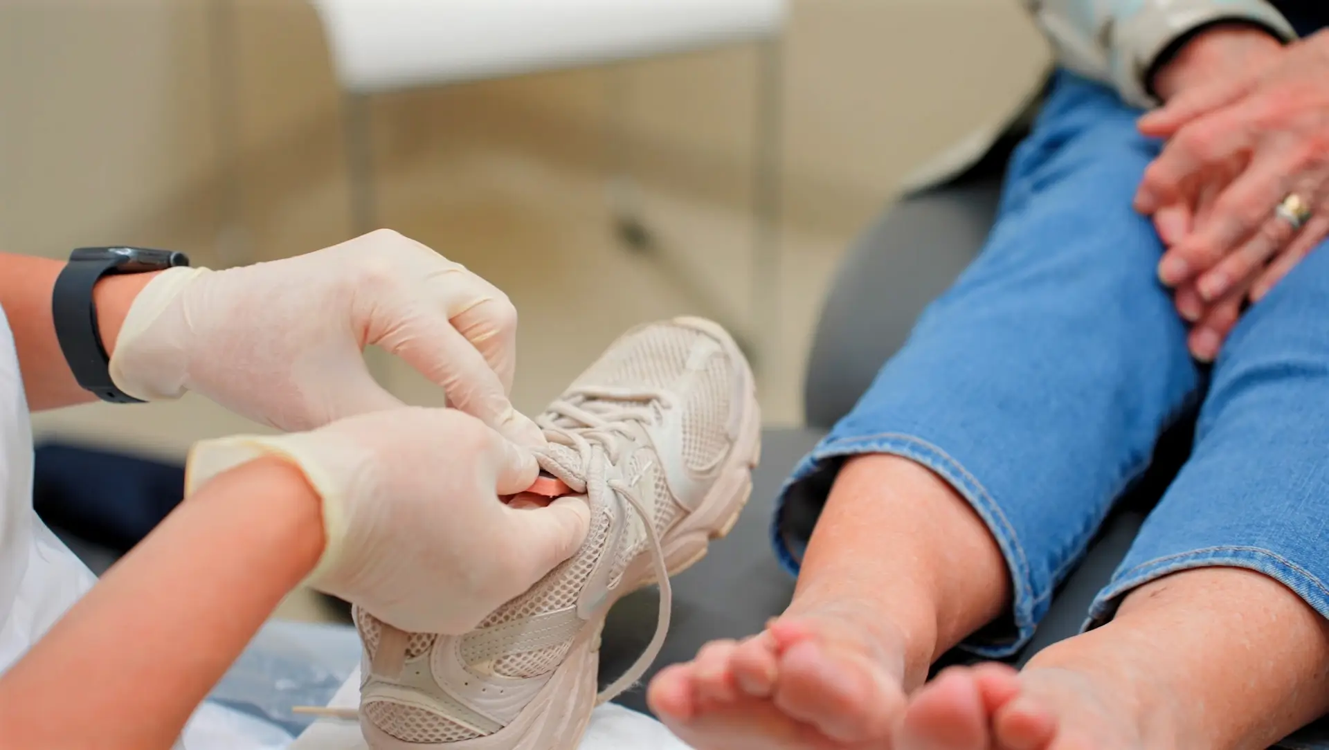 A podiatrist assists a patient with footwear fitting, highlighting the importance of proper shoes for foot comfort, mobility and foot health.