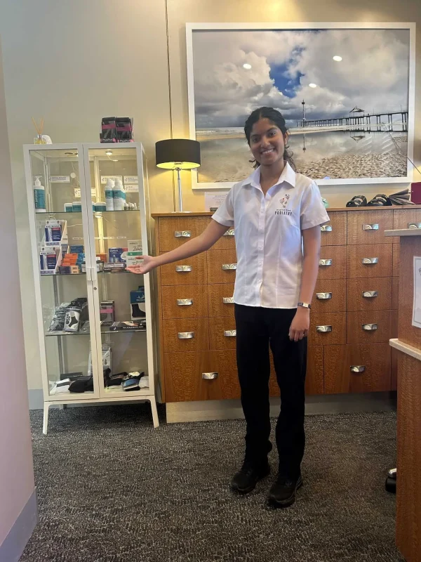 Sonia Gopinath, podiatrist at Brighton Road Podiatry, showcasing foot care products to support foot health and mobility.